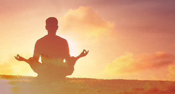 istock Silhouette of a Man Meditating Outdoors at Sunrise 2245567621