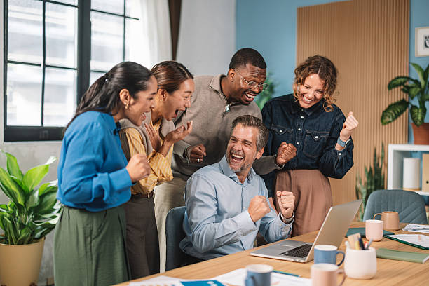istock Team Gathered Around Laptop in Office Excitement 2245567775