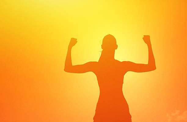 istock Woman Flexing Muscles at Sunset – Strength, Confidence, and Empowerment. 2245568166