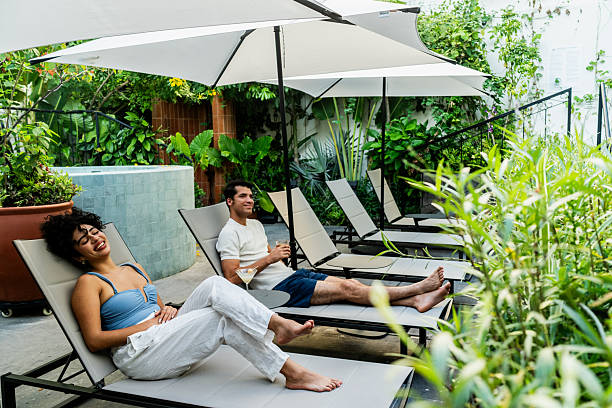 istock Young couple talking at hotel pool area 2245568365