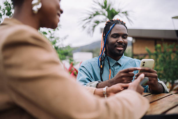 istock Colleagues using smartphones at an outdoor table 2245572157