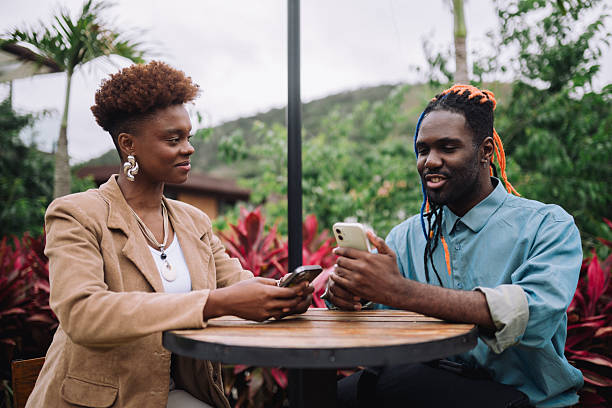 istock Colleagues using smartphones at an outdoor table 2245572158