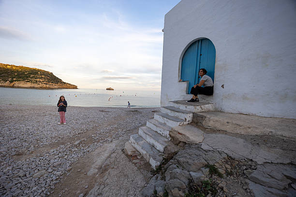 Alicante, Spain 11 02 2025 Woman and girl enjoying a tranquil day at portichol beach, alicante, spain