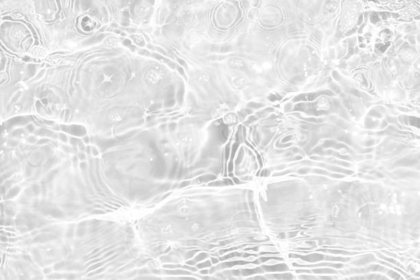 istock White water with ripples on the surface. Defocus blurred transparent white colored clear calm water surface texture with splashes and bubbles. Water waves with shining pattern texture background. 2245577585