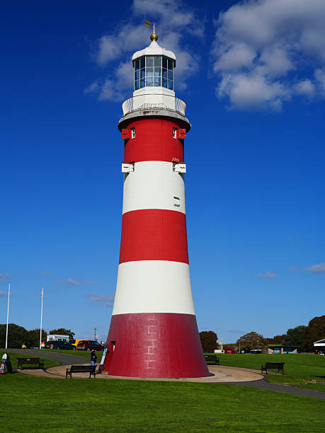 Plymouth, UK  - Sep 25 2025: Smeatons Tower on Plymouth Hoe, Devon, UK, rises in bold red and white stripes against a deep blue sky on a sunny afternoon.