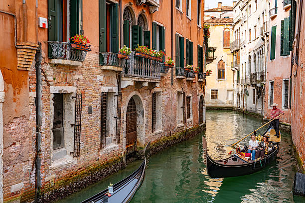 Gondola Sailing in the Venetian Canals with tourist, Venice, Italy.