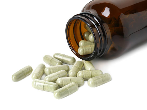 istock Scattered vitamin capsules and bottle isolated on white 2245595771
