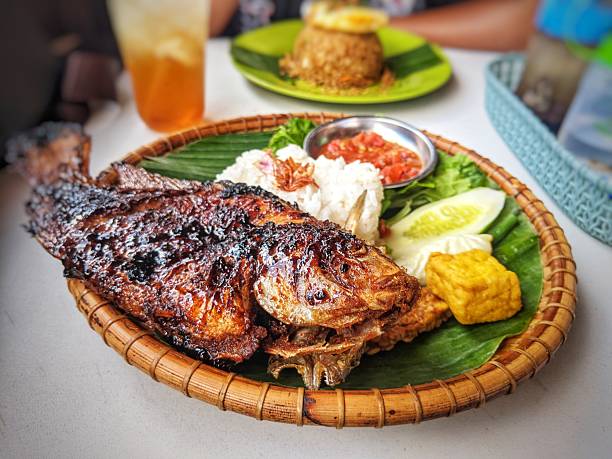 istock grilled tilapia, white rice and fresh pegetables and chili sauce served 2245597575