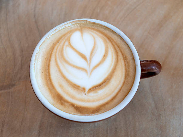istock Flat white coffee served in a mug on a wooden table 2245598117