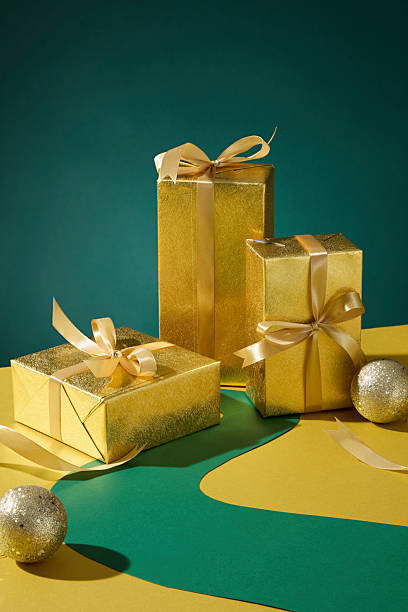 istock Gold gift boxes stacked with baubles under warm light. Elegant Christmas background for advertising or product display. 2245601184