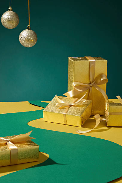 istock Artistic scene with stacked gold boxes and ornaments. Warm tone ideal for creative Christmas poster or festive backdrop. 2245601193