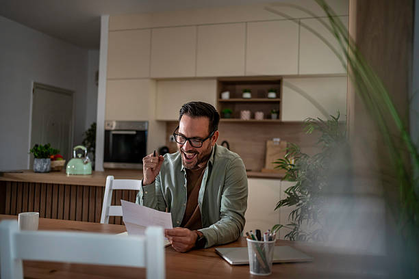 istock Man feeling excited reading good news letter at home 2245603152
