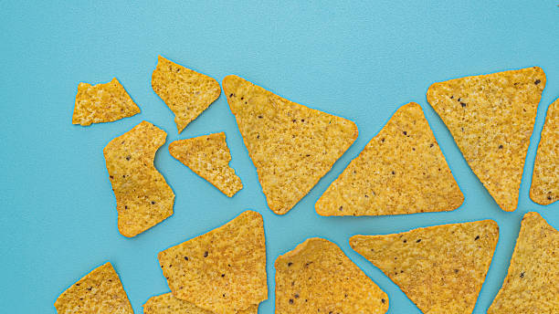 istock crispy golden tortilla chips scattered abstractly on bright blue background surface. 2245603995