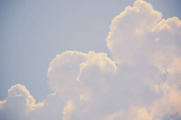 Soft fluffy clouds in a serene blue sky create a tranquil atmosphere, evoking feelings of peace and calmness, perfect for nature-themed projects or backgrounds with copy space