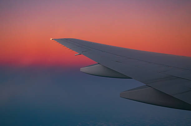istock Airplane wing in flight during sunset with vibrant sky 2245608862