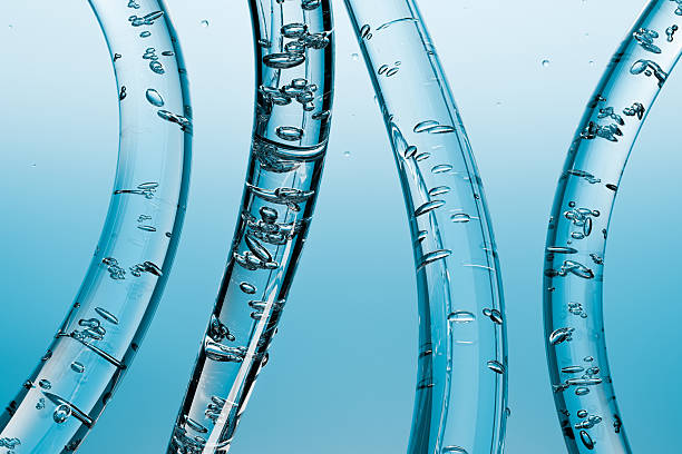 istock Transparent glass tubes with floating water bubbles on a blue background. Abstract 3D, symbolizing purity, hydration, science, cosmetics, and product technology. 2245609741