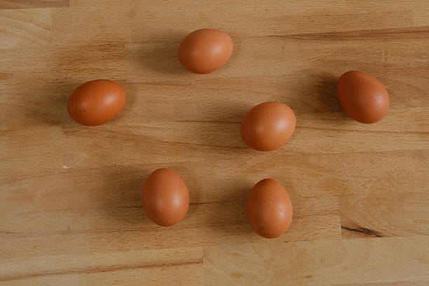 Elevated view of fresh, brown eggs on wooden table