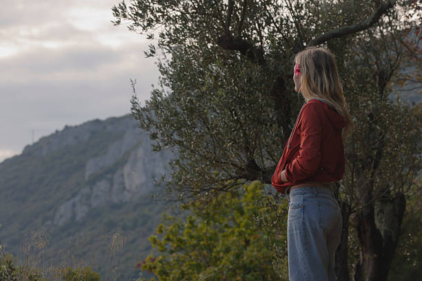 Young woman on hilltop above forest, Liguria