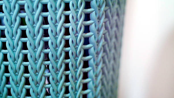 Close-up of intricately braided pale blue chains creating a textured pattern with a soft blurred background emphasizing craftsmanship and calm tones.