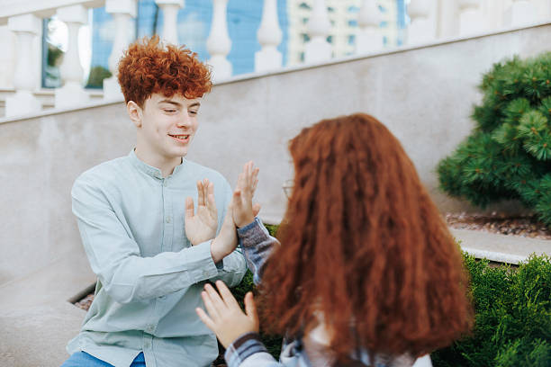 istock Redhead boy cheering up an upset girl while playing together on steps 2245617275