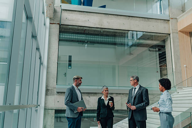 istock Business people networking and collaborating in office lobby 2245618334
