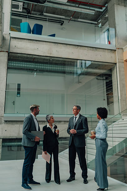 istock Business people having coffee break in corporate office setting 2245618340