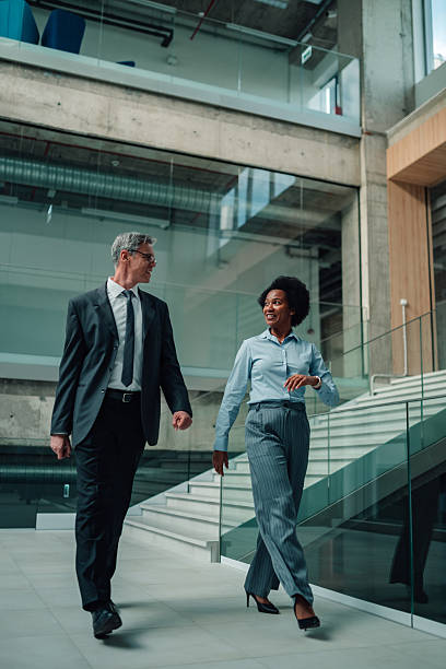 istock Business colleagues walking and conversing in modern office building 2245618367