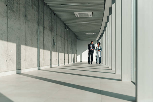 istock Medical professionals walking through modern hospital hallway discussing work 2245618469
