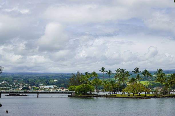 istock Cloudy harbor view with town along tropical shoreline 2245619643