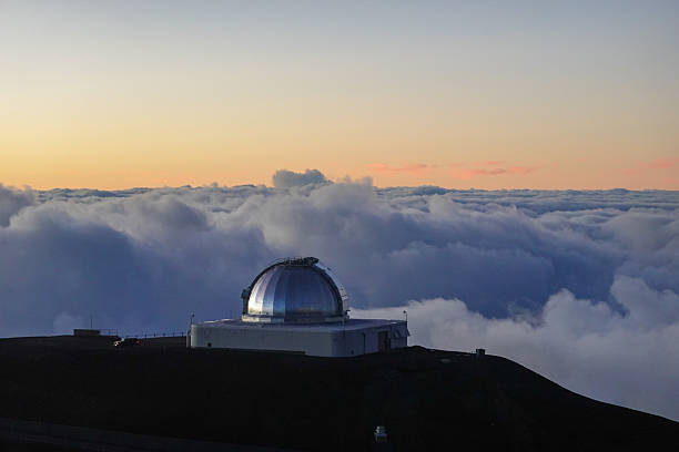 A solitary observatory dome stands on a ridge as soft dawn light begins to illuminate the clouds and sky behind it. The scene feels quiet and anticipatory, suggesting the start of a new observing night or early morning. This image suits astronomy outreach, science storytelling, and inspirational designs that combine technology with serene natural beauty.