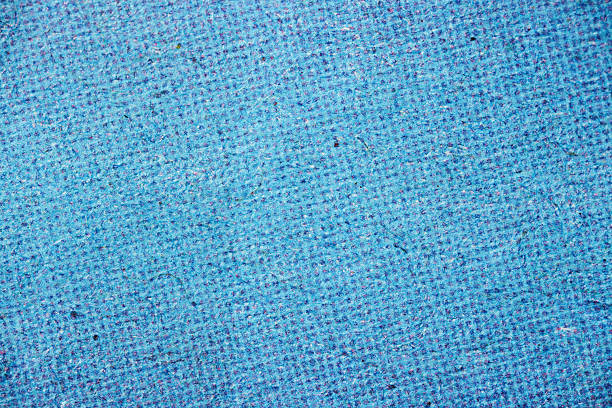 Close-up of dense cyan halftone dots on textured fibrous paper, forming a uniform blue tone with visible pulp and ink layering.