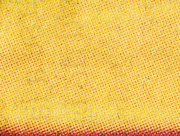 Macro shot of yellow and magenta halftone dots on fibrous paper, showing a gradient effect with visible grain and ink texture.