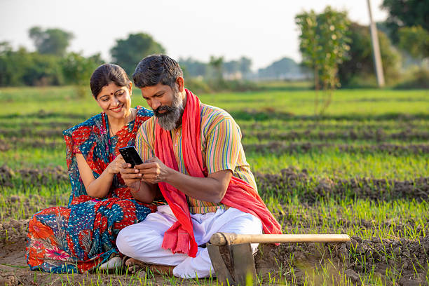 istock Indian farmer with wife using smartphone at agriculture field. 2245627134