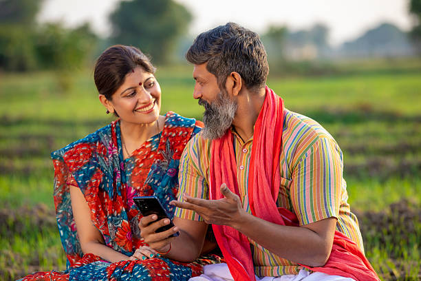 istock Indian farmer with wife using smartphone at agriculture field. 2245627150