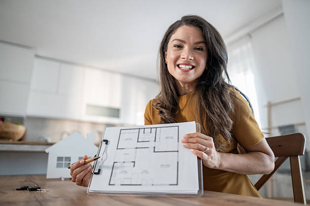 istock Female real estate agent explaining house plan 2245627521