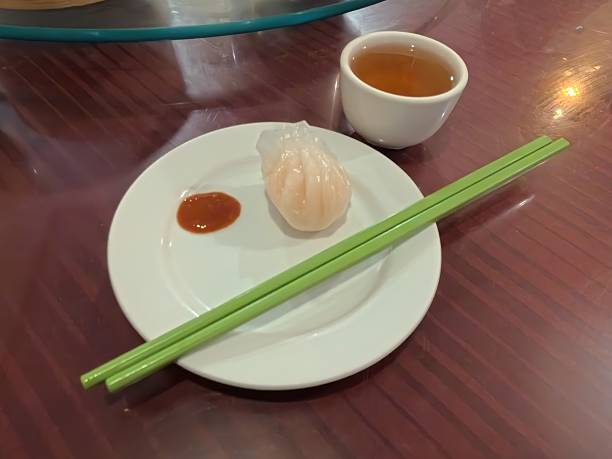 istock Classic Dim Sum Serving: Har Gow (Shrimp Dumpling) with Tea and Chopsticks 2245629319