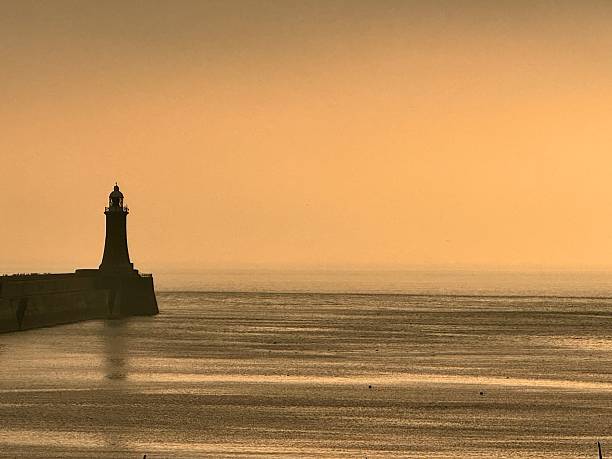 istock Tynemouth lighthouse and pier reflecting on the sea at sunrise 2245630004