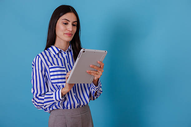istock Woman holding a tablet, browsing online content. She is connecting to the internet for work, education, or entertainment 2245630830