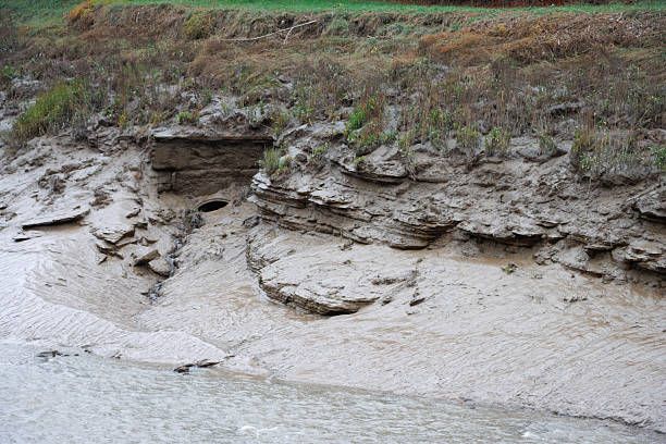 istock Water outlet pipe in muddy riverbank 2245631665