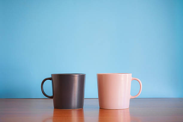 istock Black and Pink ceramic coffee cup on wood desk with blue background. 2245631728