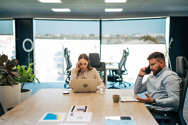 istock Business people experiencing work stress and a headache in office 2245636557