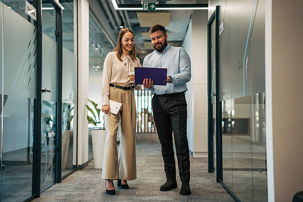 istock Business colleagues discussing project ideas in office hallway 2245637350