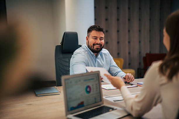 istock Business people collaborating on documents in office meeting 2245639095