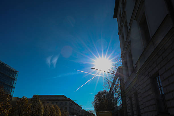 Modern Architecture with Glass Facade and Sunburst in Blue Sky