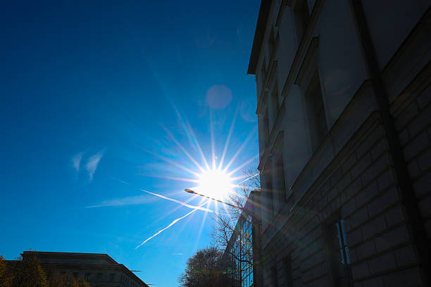 Modern Architecture with Glass Facade and Sunburst in Blue Sky