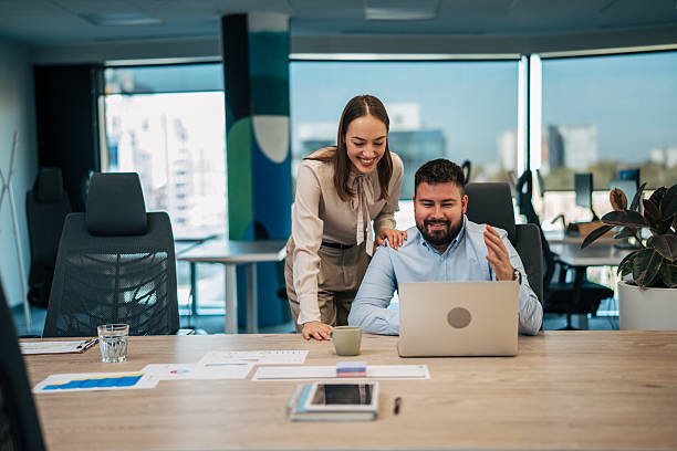istock Colleagues collaborating on laptop, working together in office 2245639441