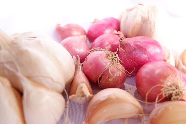 Close up of a completed home grown garlic and onion (Red Baron and Stuttgarter) plaits hanging up in a kitchen