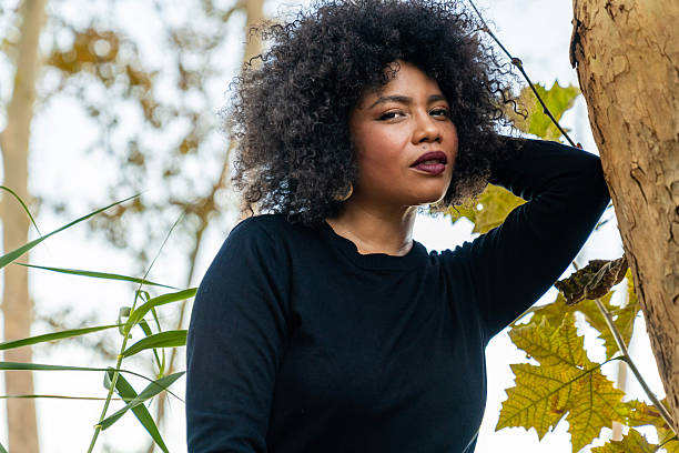 African american woman looking at camera, feeling confident in autumn nature