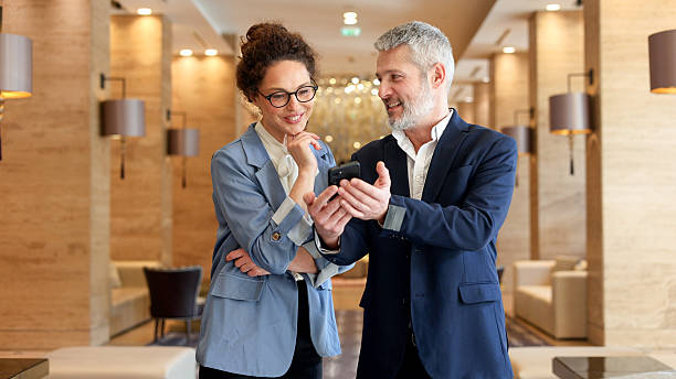 istock Business colleagues discussing new ideas while collaborating over a smartphone in a modern hotel lobby 2245650676