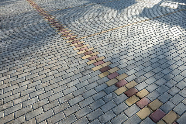 Sunlight shines on the neatly arranged gray bricks on the ground.